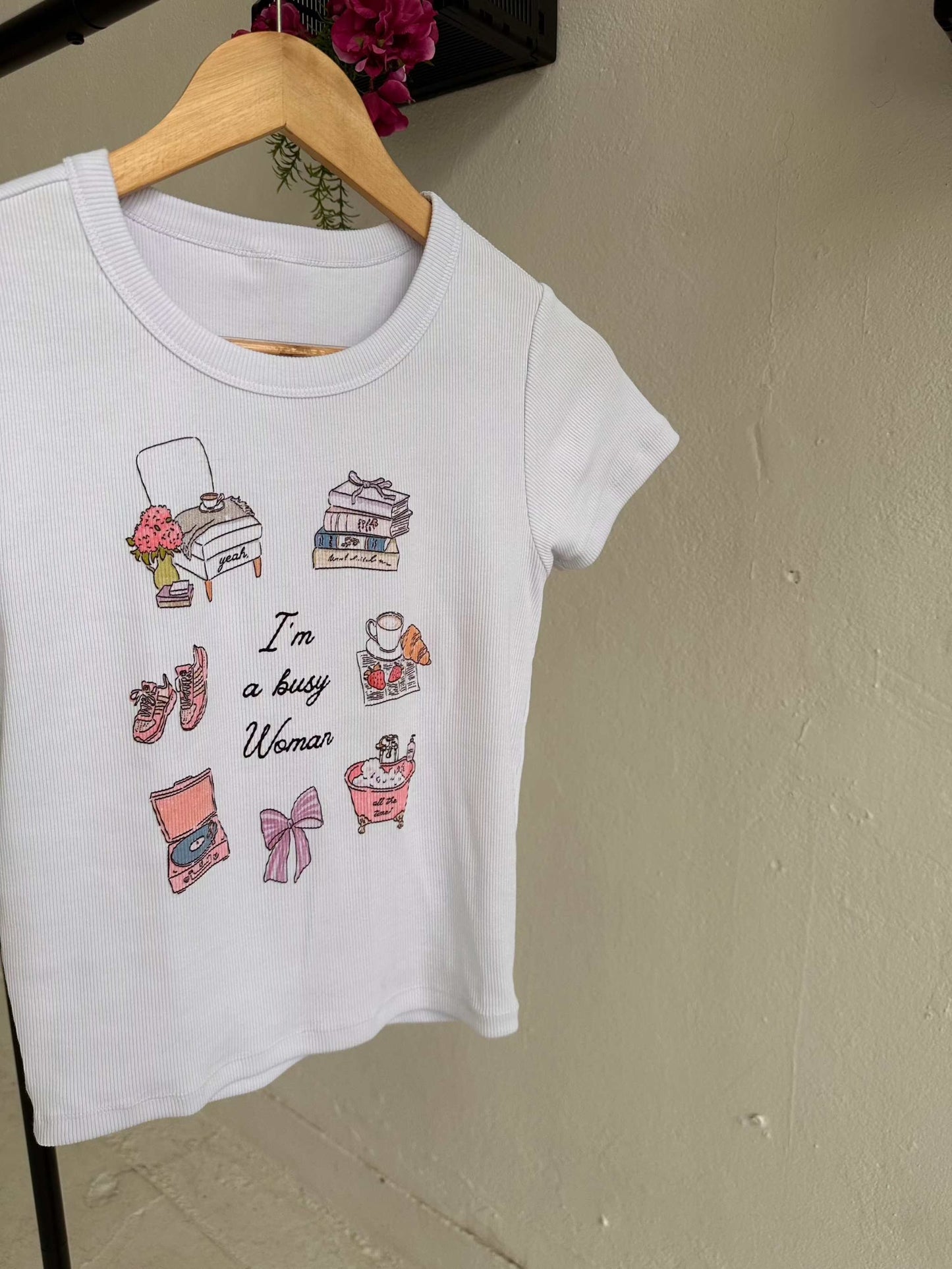 Busy Woman Tee. A slim fit ribbed tee inspired by books, music, feminine hobbies, and the Sabrina Carpenter song Busy Woman is featured with the books Deep End and Happy Place. A super soft bookish summer t-shirt that is perfect for the bookstagram girls and the booked and busy fangirls.