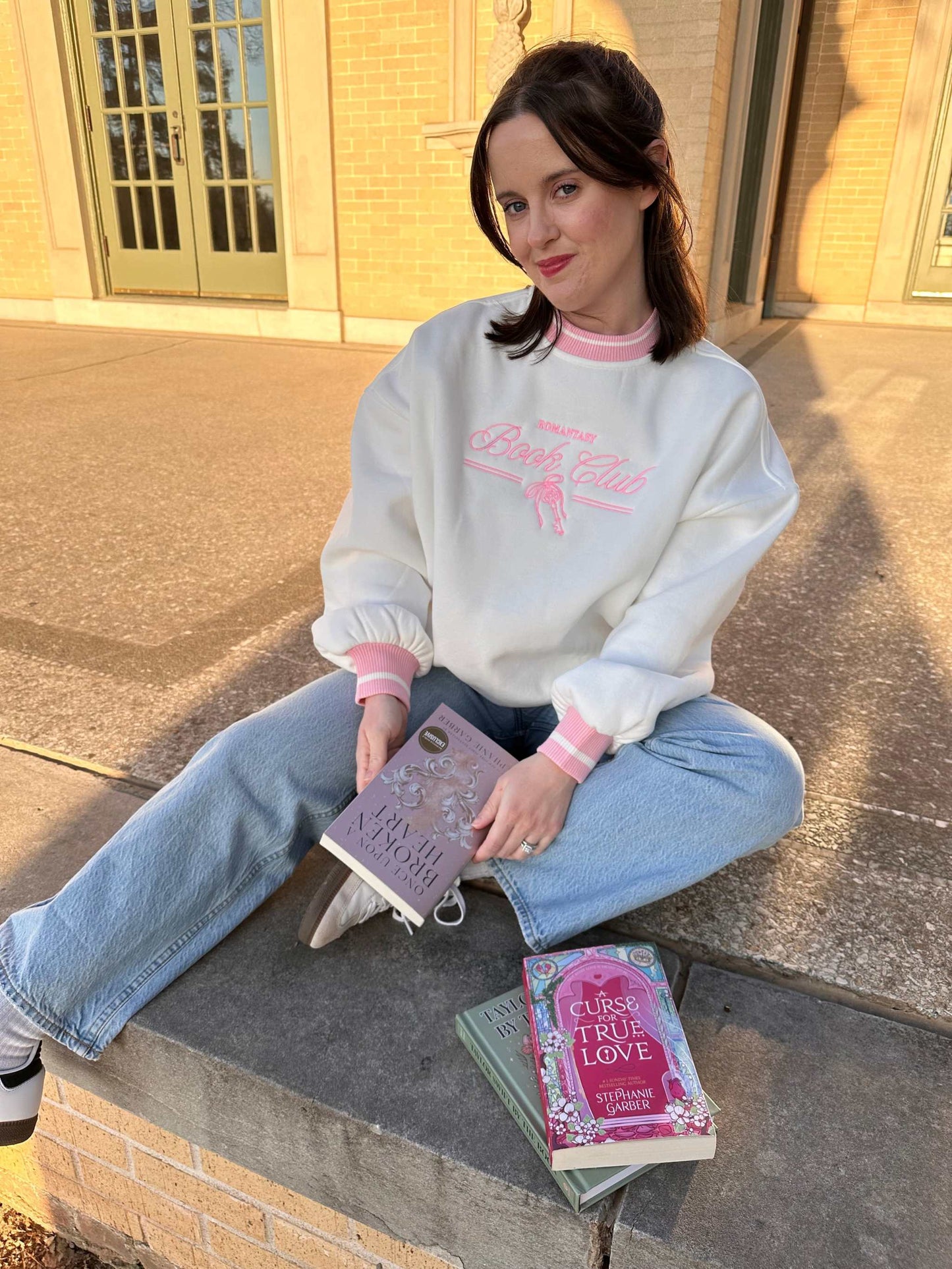 Romantasy Book Club Crewneck. Embroidered sweatshirt with a stylish pink trim collar and sleeves. Book merch for lovers of the romance and fantasy bookish genres.