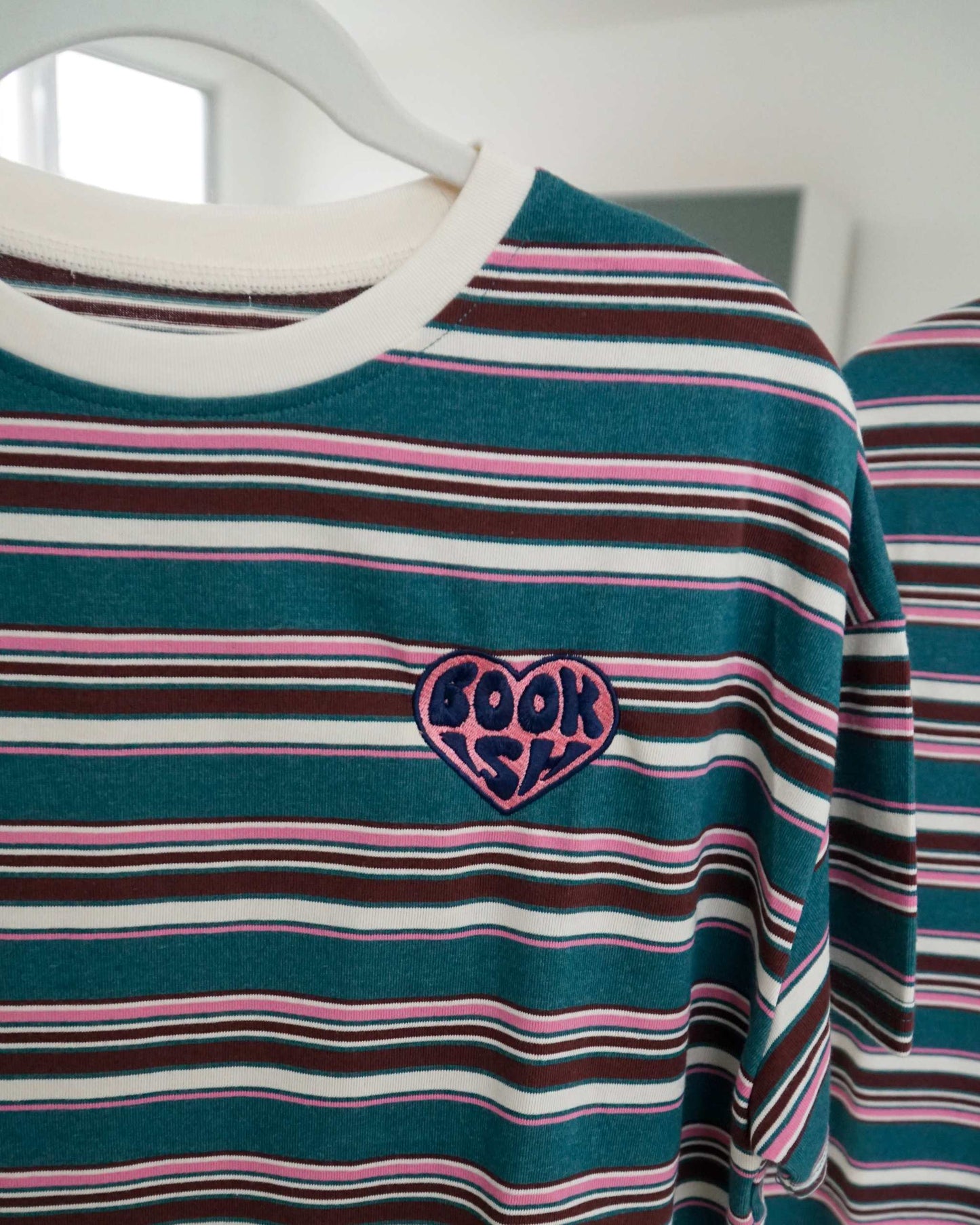 The Bookish Retro Boxy Tee with stripes and an embroidered design from Next Chapter Bookwear, a high quality bookish apparel shop.