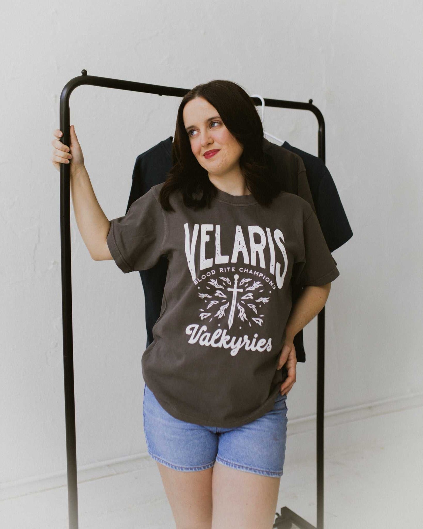 Velaris Valkyries tee featuring a dark gray fabric and white, screen printed design. From A Court of Silver Flames. Officially licensed by Sarah J. Maas.