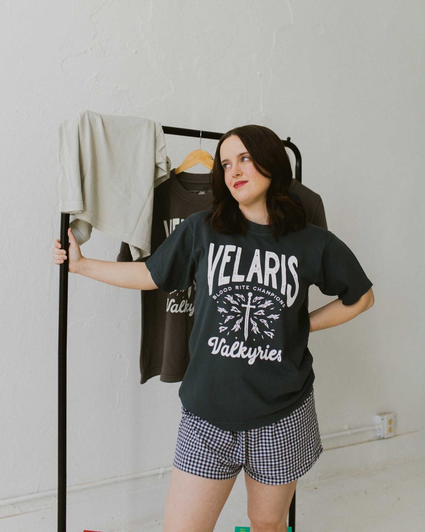 Velaris Valkyries tee featuring a deep navy fabric and white, screen printed design. From A Court of Silver Flames. Officially licensed by Sarah J. Maas.