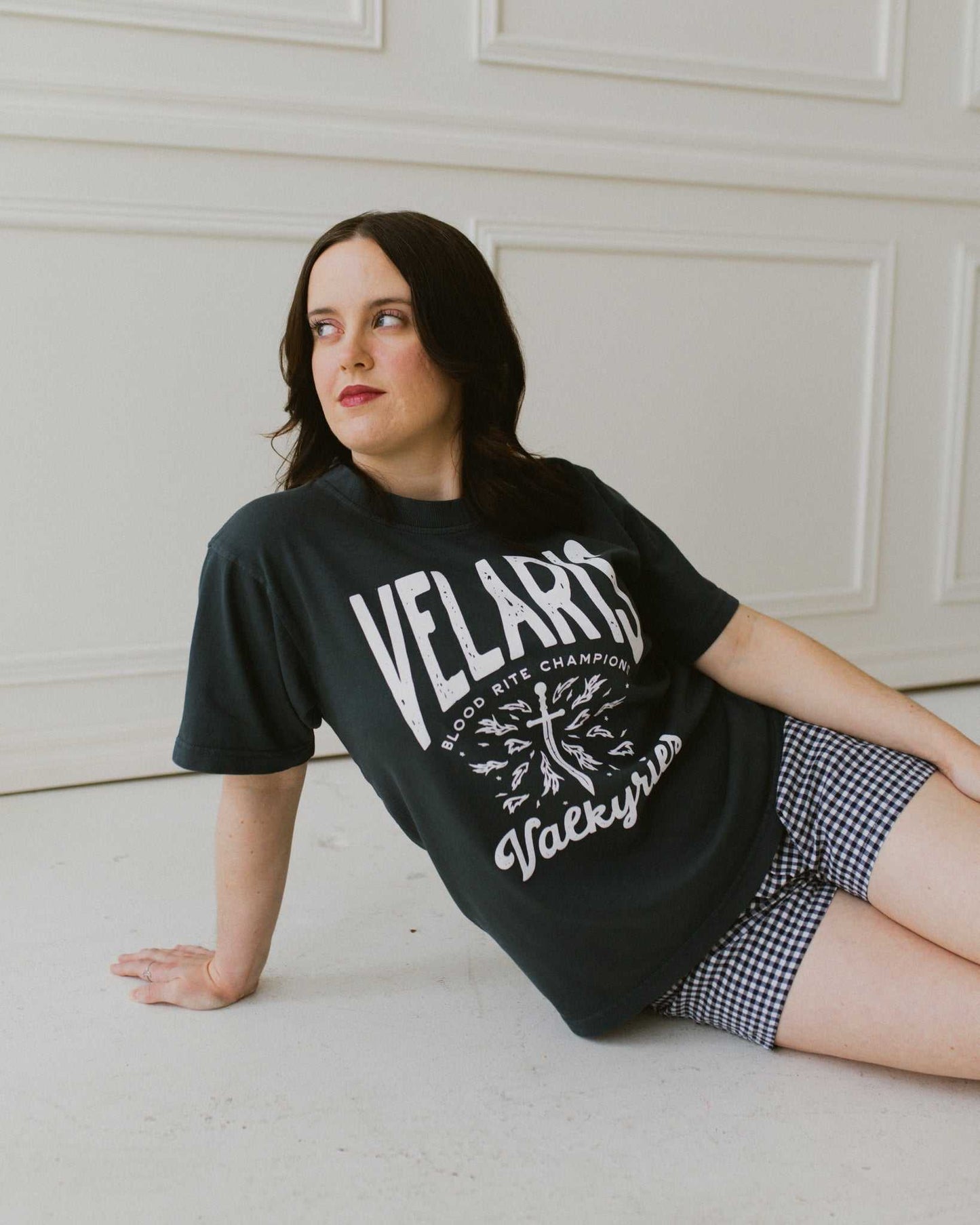 Velaris Valkyries tee featuring a deep navy fabric and white, screen printed design. From A Court of Silver Flames. Officially licensed by Sarah J. Maas.
