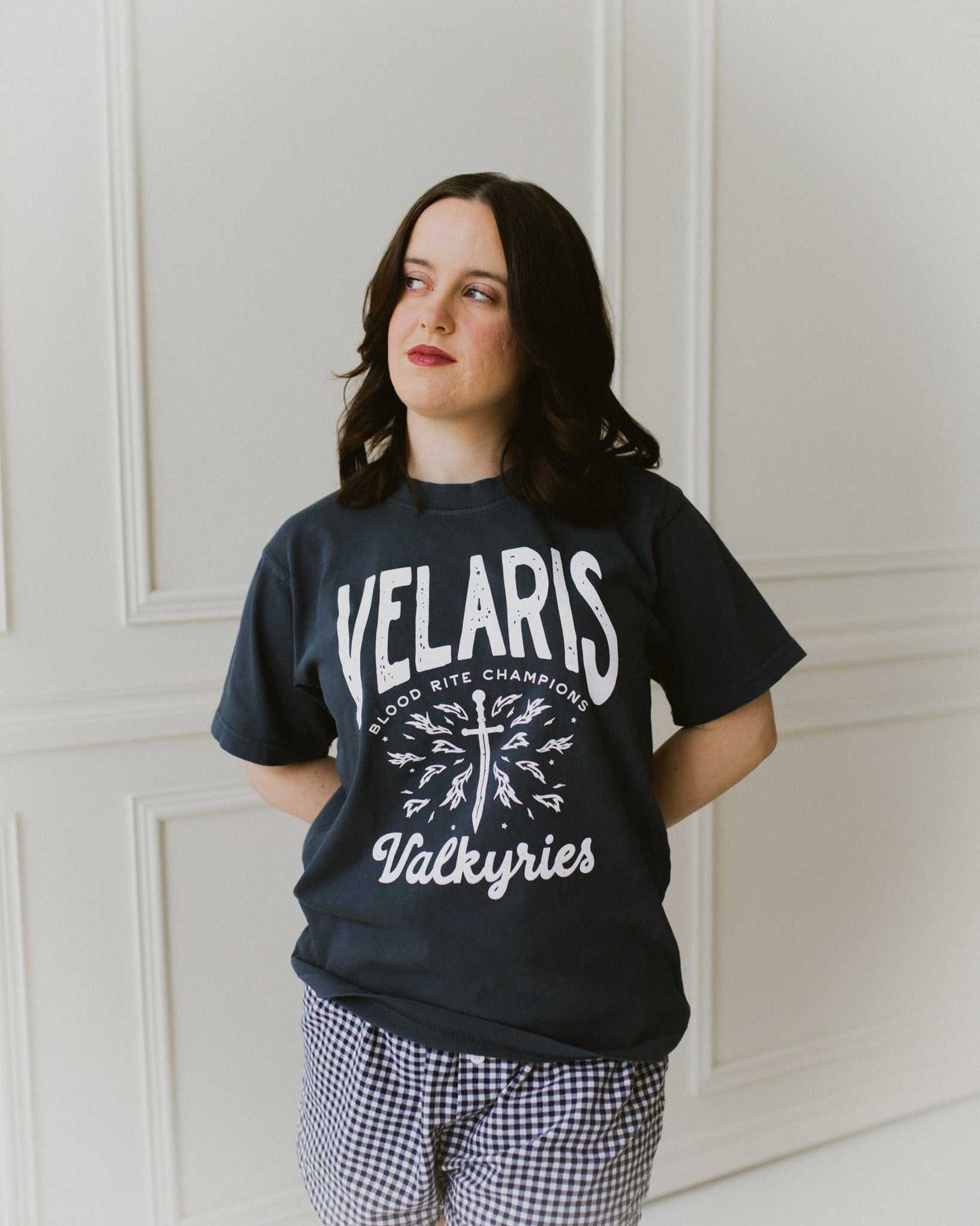 Velaris Valkyries tee featuring a deep navy fabric and white, screen printed design. From A Court of Silver Flames. Officially licensed by Sarah J. Maas.