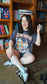 Woman sitting on the floor in front of a bookshelf wearing a 'Gothic Fantasy' t-shirt. Striped oversized boxy Gothic Fantasy Tee / t-shirt. For book lovers of the romantasy genre. 