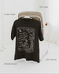 The One Dark Window Tee from Next Chapter is officially licensed by Rachel Gillig and inspired by the Shepherd King Duology. Next Chapter is an official retailer of Rachel Gillig licensed merchandise. This image shows the One Dark Window Tee in the vintage black color option.