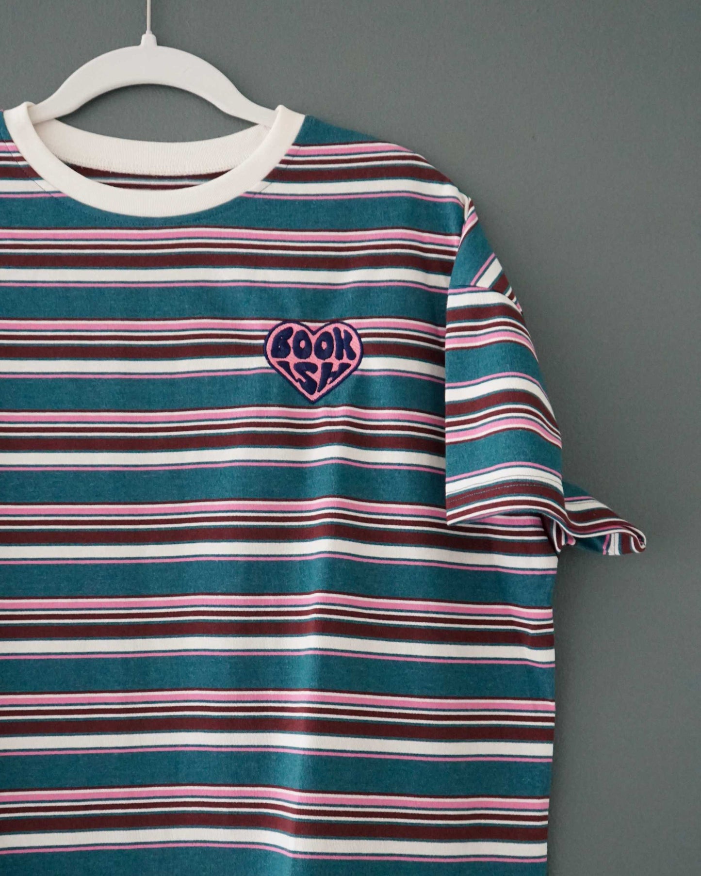 The Bookish Retro Boxy Tee with stripes and an embroidered design from Next Chapter Bookwear, a high quality bookish apparel shop.