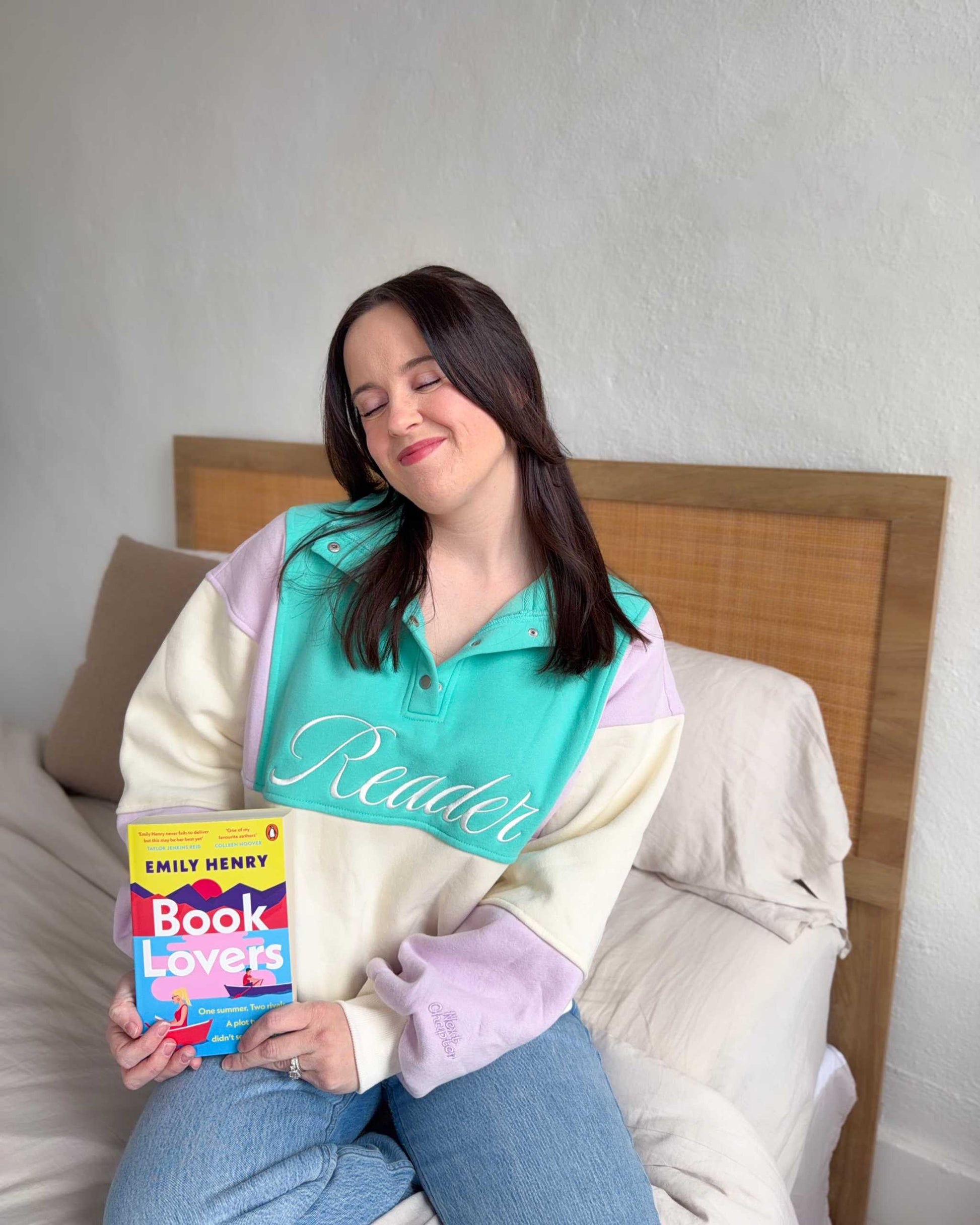 The Reader Colorblock Pullover from Next Chapter is oversized, with a quarter button-up style. This variant is lilac, teal, and ivory and has the word 'Reader' embroidered across the front. Next Chapter offers high quality bookish merch and apparel. 