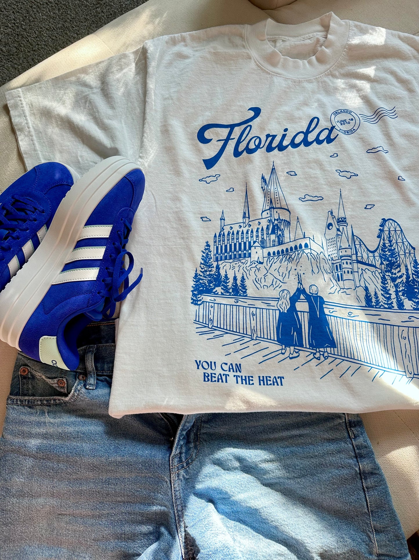 A t-shirt that depicts the Wizarding World of Harry Potter theme park. The t-shirt also references Taylor Swift's song "Florida!!!" as well as the opening date of the park. 