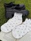 White Gothic Fantasy Reader Socks with black polka dots and ruffle hem paired with black Mary Jane shoes on grass