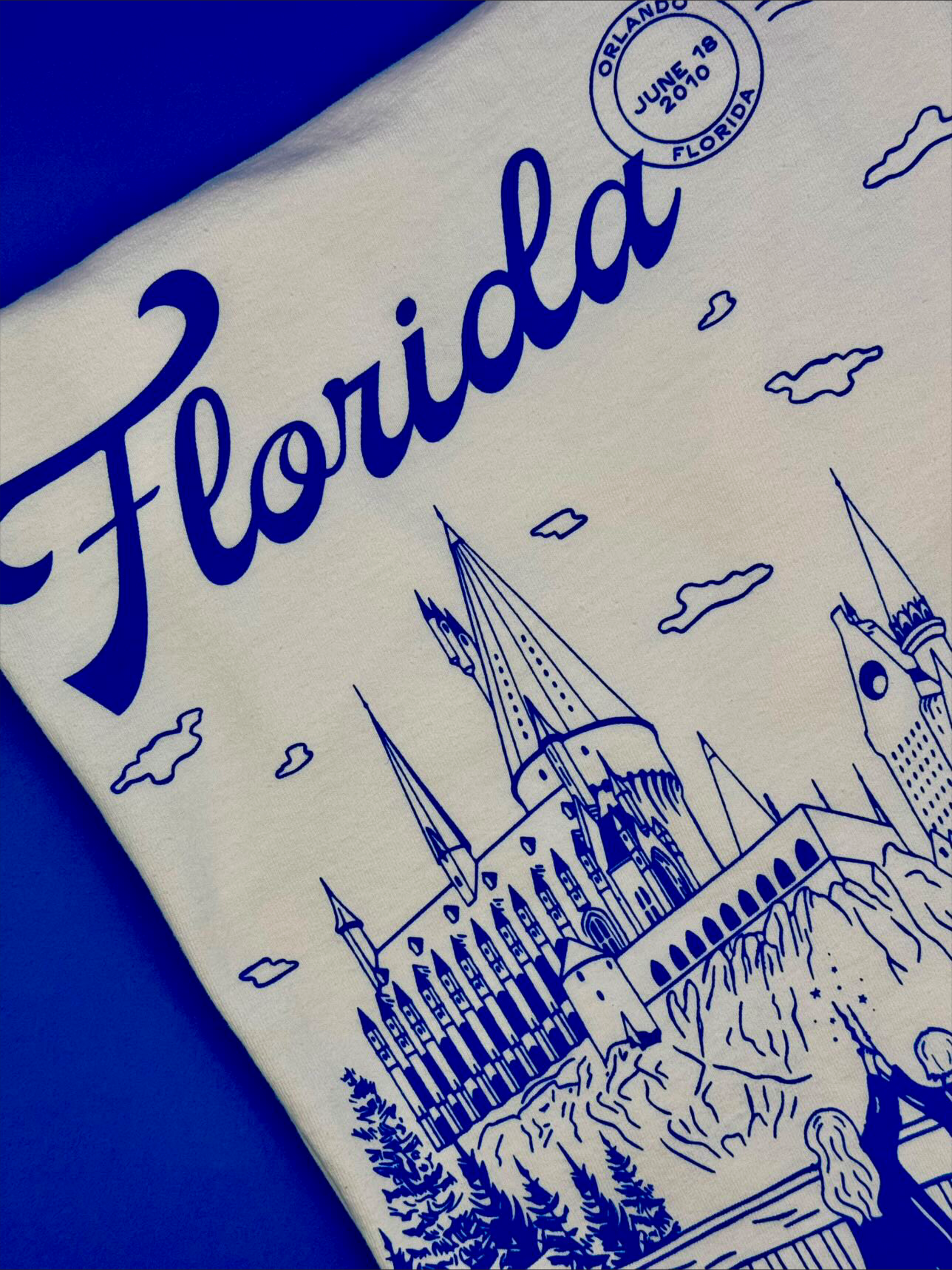 A t-shirt that depicts the Wizarding World of Harry Potter theme park. The t-shirt also references Taylor Swift's song "Florida!!!" as well as the opening date of the park. 