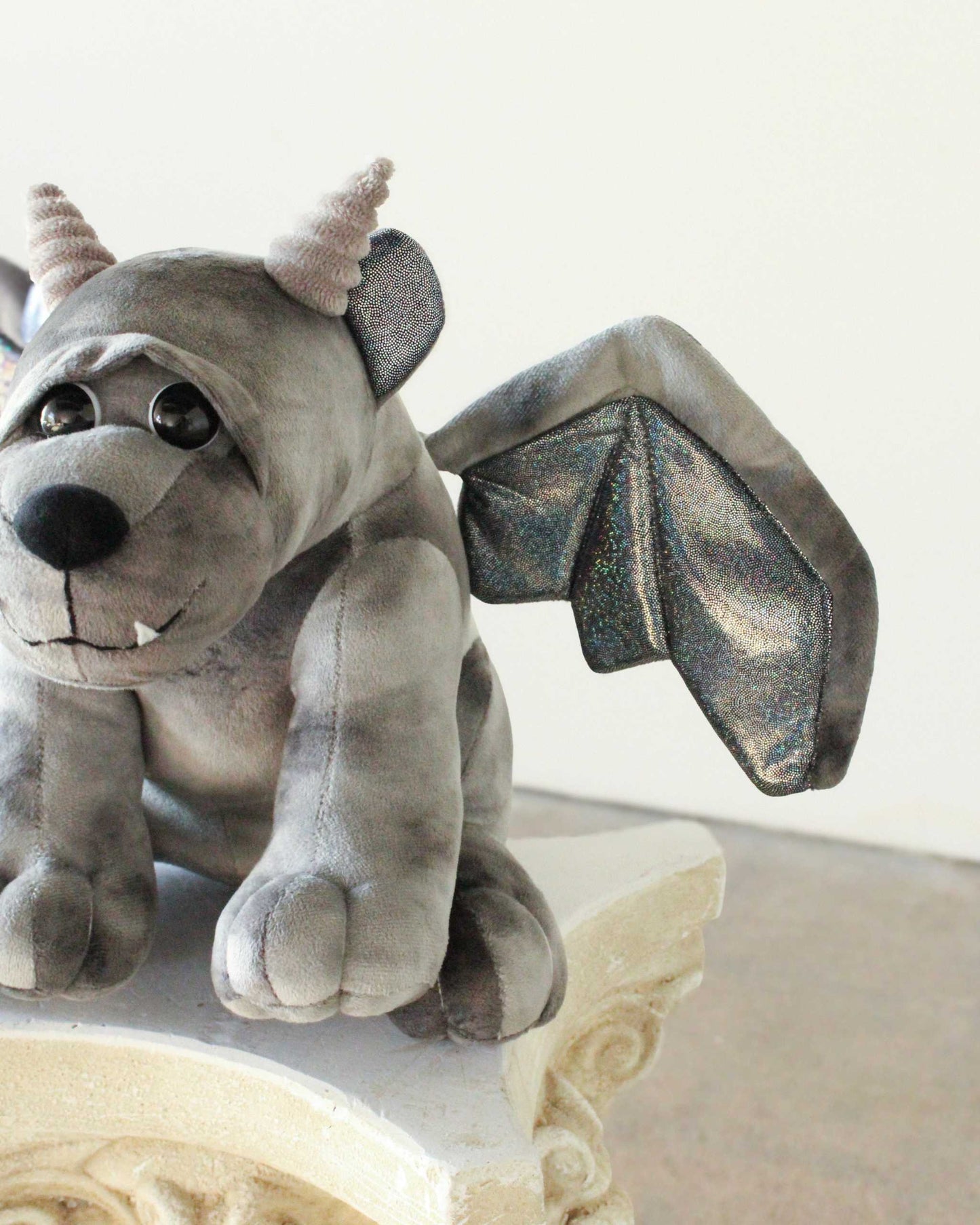 Bartholomew Gargoyle plush in soft gray fabric with small horns, a toothy smile and sparkly bat wings