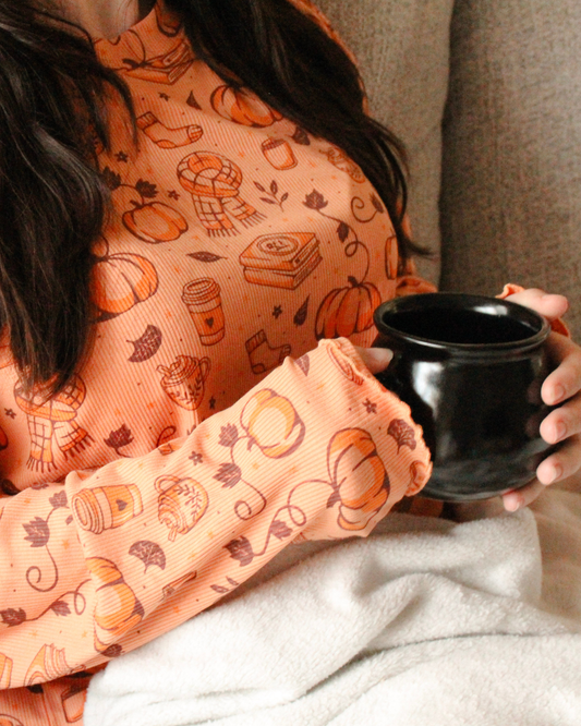 Woman wearing the all things autumn bookish lounge set from Next Chapter. A cozy bookish loungewear pjs autumn set.