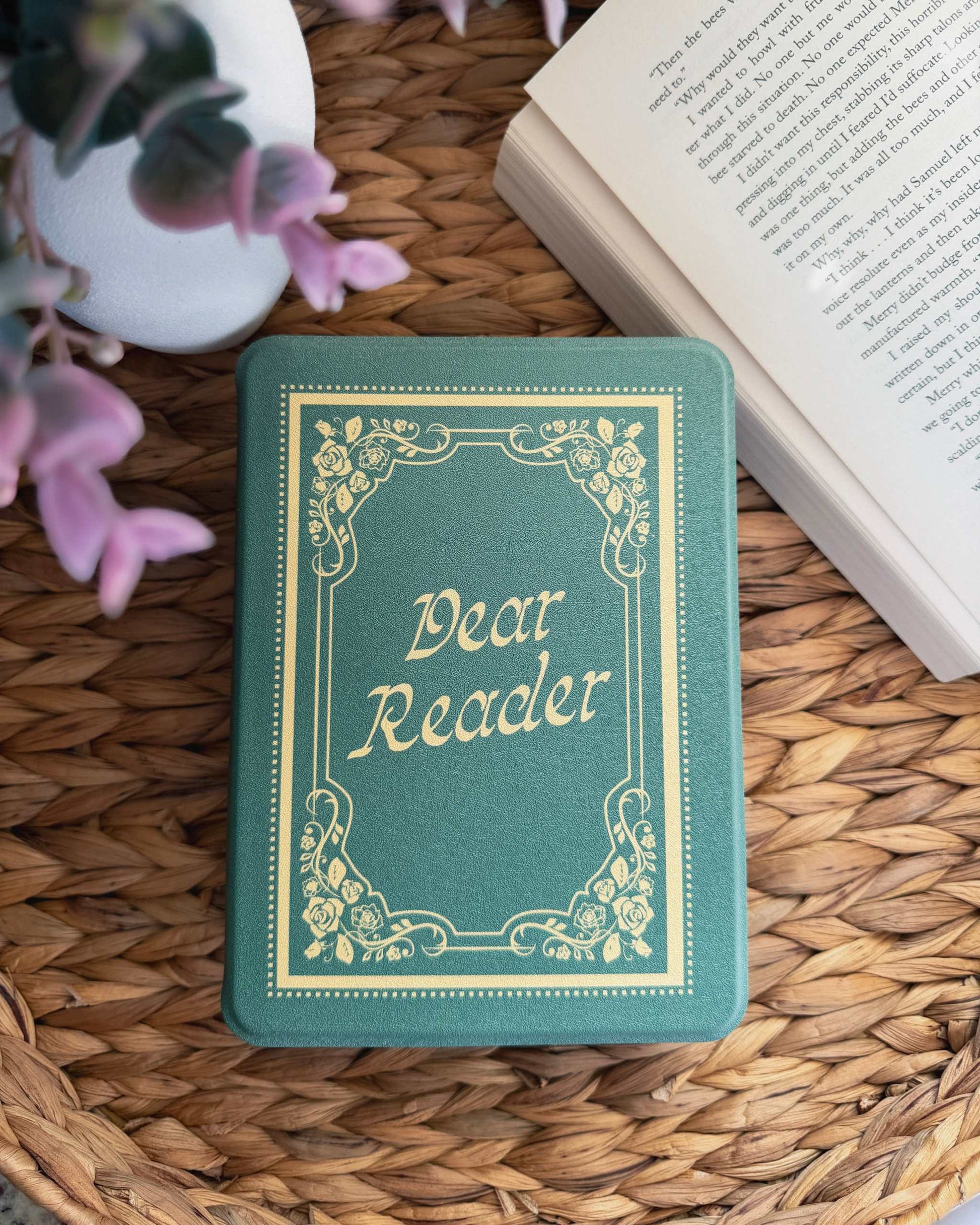 Small green kindle case that looks like a book with 'Dear Reader' on a woven surface. The Dear Reader Kindle case from Next Chapter is inspired by the Taylor Swift song 'Dear Reader.' 