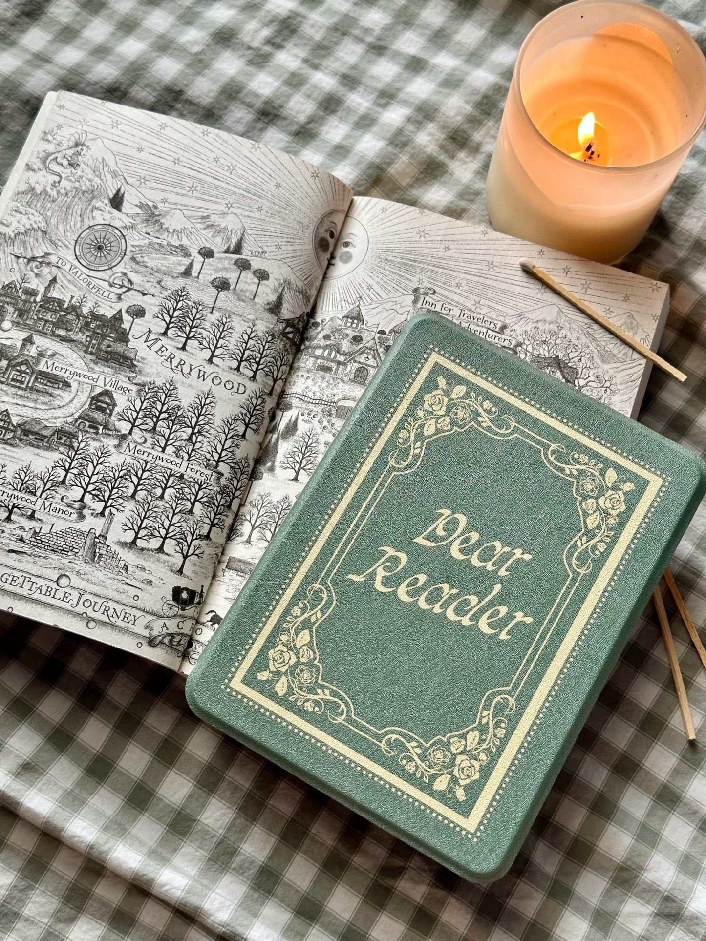 Small green kindle case that looks like a book with 'Dear Reader' on an open book. The Dear Reader Kindle case from Next Chapter is inspired by the Taylor Swift song 'Dear Reader.' The case has a vintage and soft feminine style and looks like a real book.
