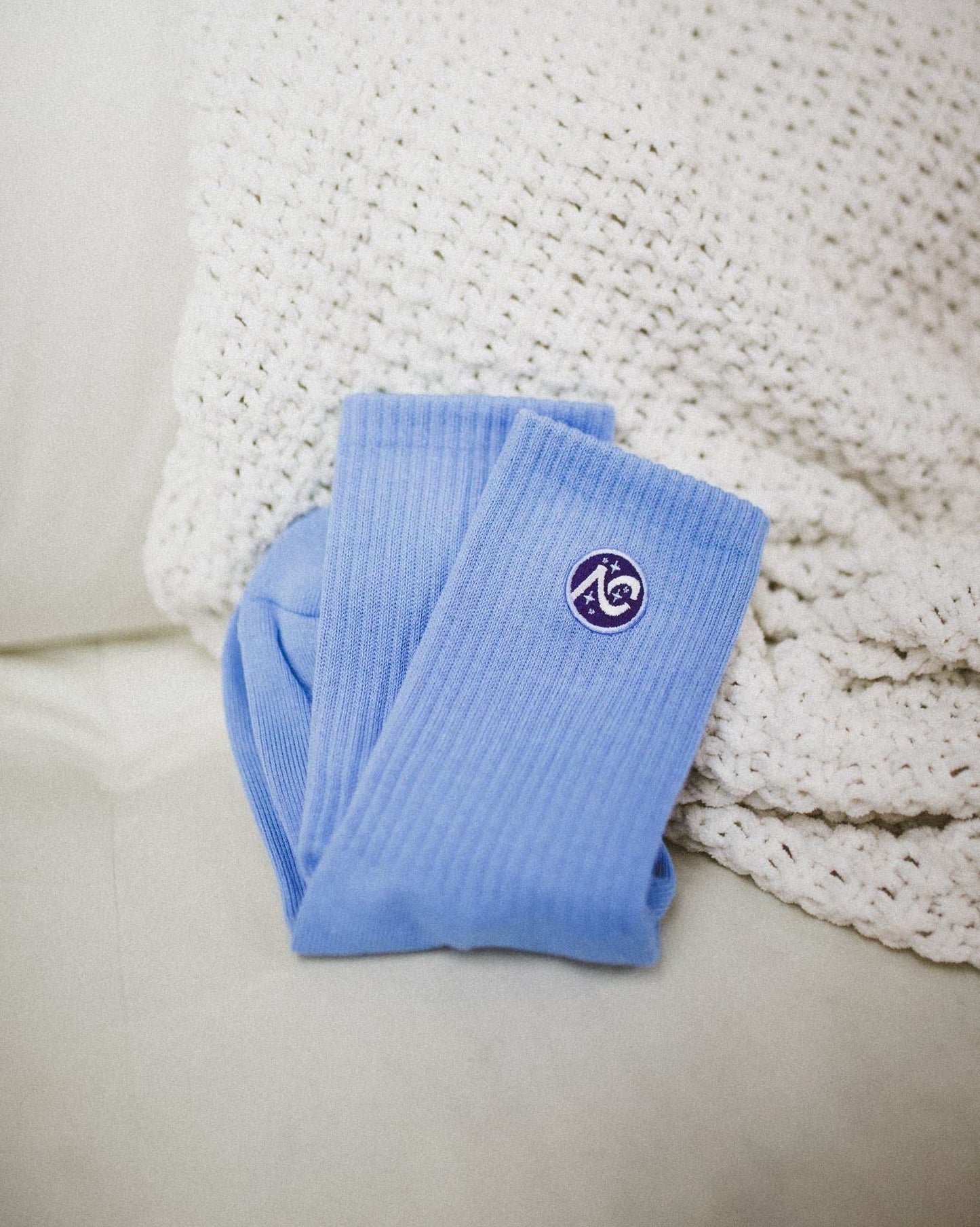 The Next Chapter Crew Socks are shown in the blue color option. Cozy bookish socks for the readers. 