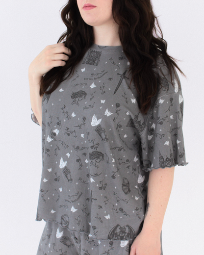A woman wearing the knight and the moth lounge set from Next Chapter. This is a cozy bookish pajama set for fantasy book lovers, inspired by The Knight and the Moth.
