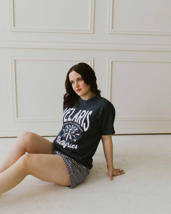 Velaris Valkyries tee featuring a deep navy fabric and white, screen printed design. From A Court of Silver Flames. Officially licensed by Sarah J. Maas. 